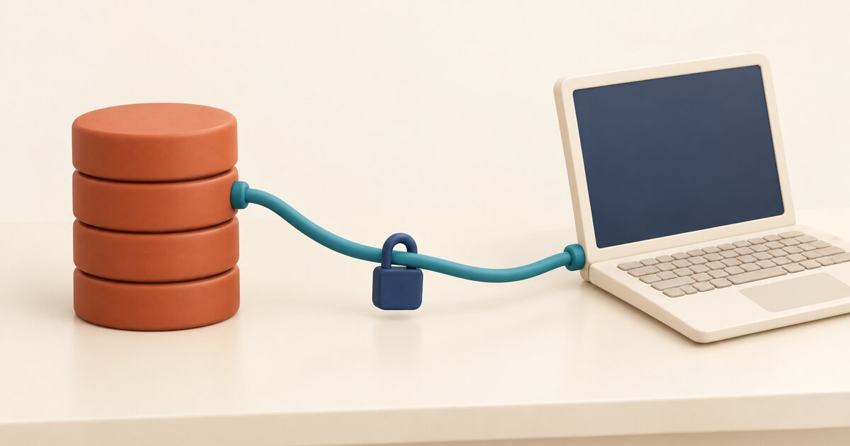 生成りの机の上で、赤褐色の円盤を積み重ねた円柱とクリーム色のノート PC が 1 本のティール色のケーブルでつながり、ケーブルの中央に小さなネイビーの錠前が留まっている